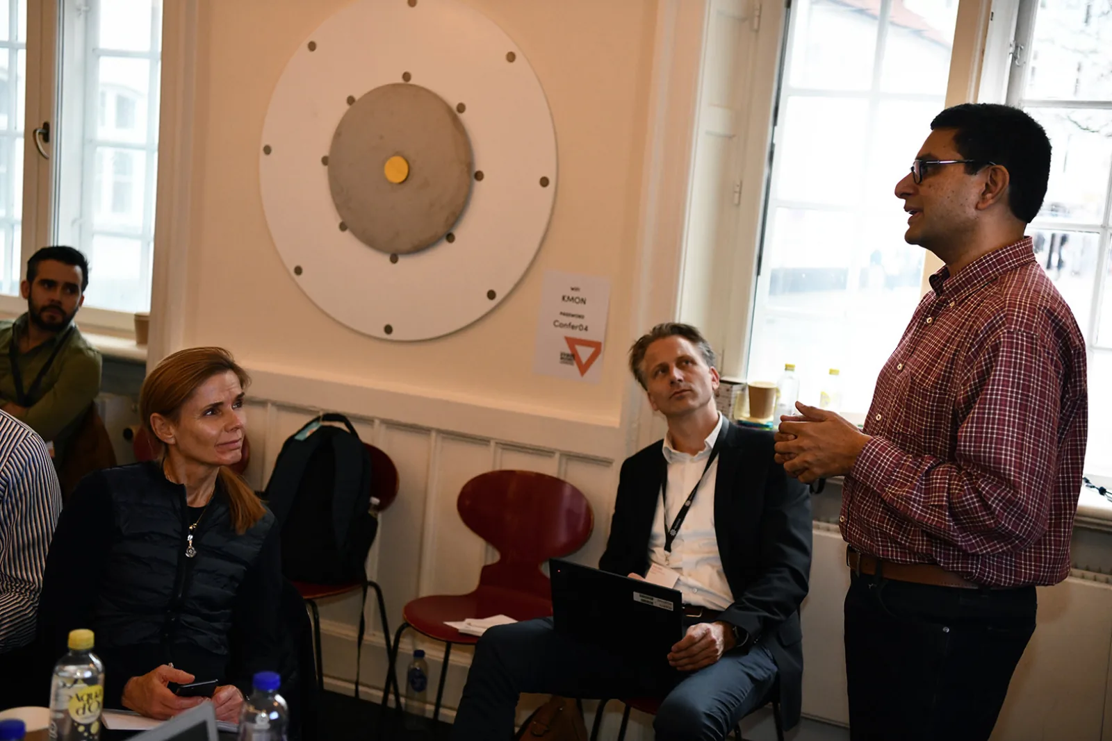 Kashyap Kompella in a red shirt leading a small-group discussion in Aarhus
